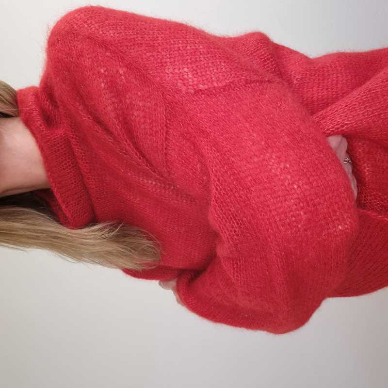 A woman wearing an elegant red, silk mohair, knitted sweater.