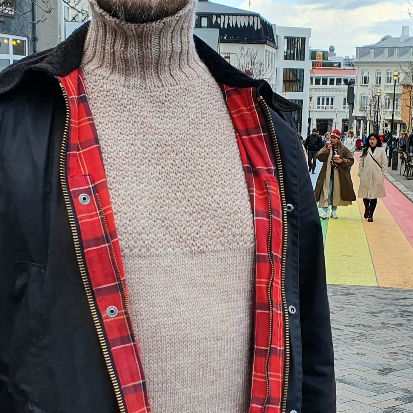 A man wearing a beige, high-collared, long-sleeved Duggari sweater in Reykjavik city center.